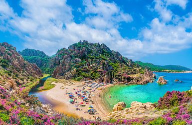 Bucht mit Felsformationen aus rosa leuchtenden Granitgestein