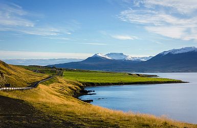 weite Landschaft am Wasser, Berge im Hintergrund