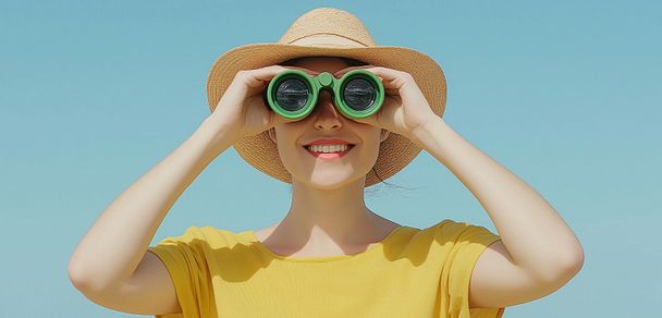 Frau schaut mit Fernglas