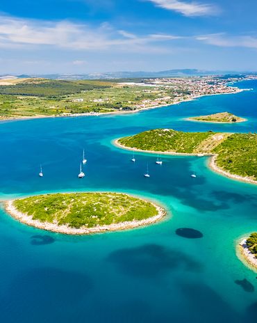 einzelne Inseln und Boote vor einer Küste