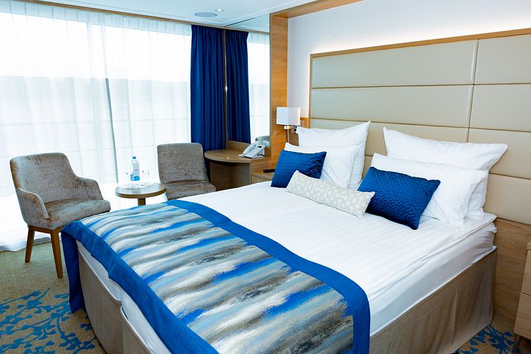 Außenkabine mit gemütlichem Bett und kleiner Lounge
