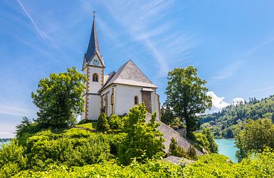 Weiße Kirche auf Hügel am See