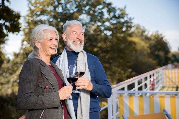 Paar steht an Deck und prostet sich mit Wein zu