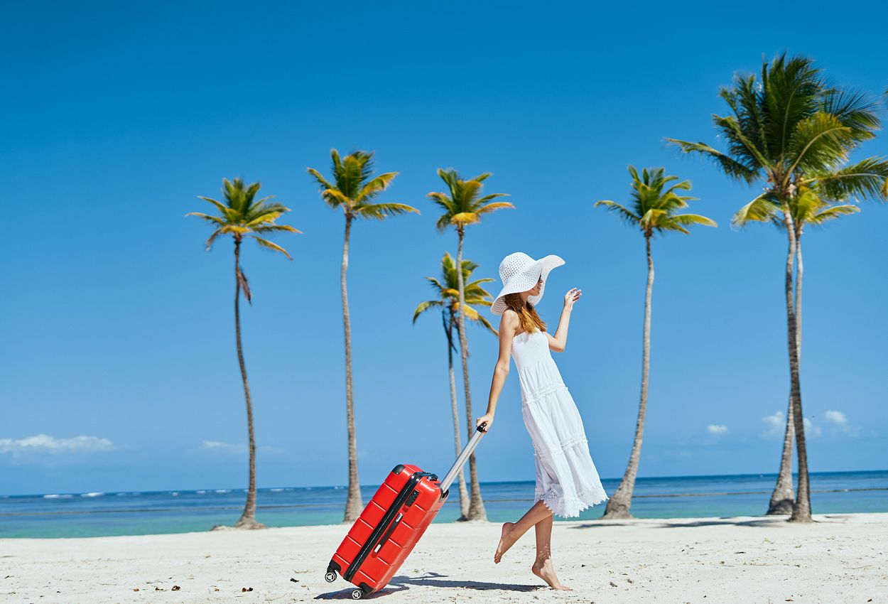 Eine Frau mit Koffer am Strand