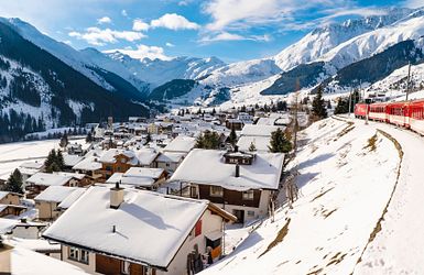Rote Bahn fährt durch Berglandschaft