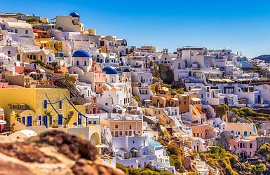 Weiß, blaue und orangene Gebäude auf den Felsen von Santorini  
