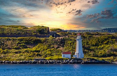 Weißer Leuchtturm an Bucht