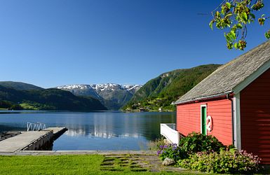 Rotes Holzhaus mit eigenem Steg am Fjord